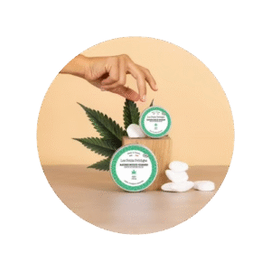 Baume au chanvre sur un socle en bois et une feuille de chanvre juste derrière